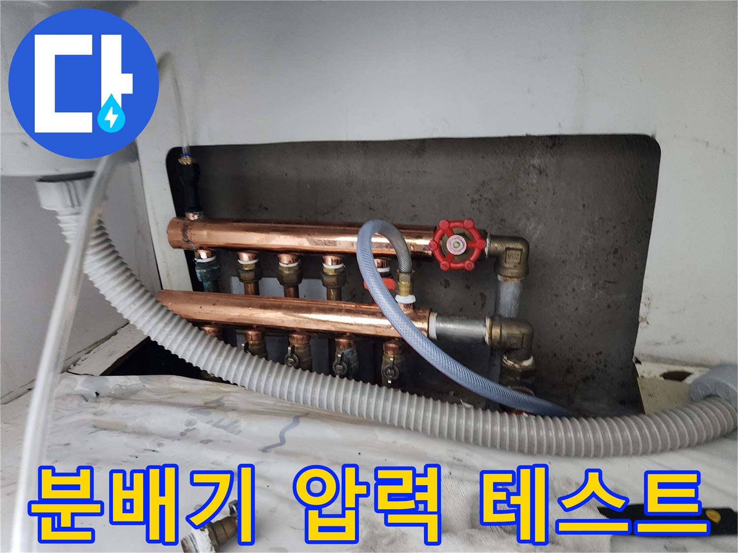 난방 분배기에 연결된 압력 측정용 호스와 밸브의 상세 모습