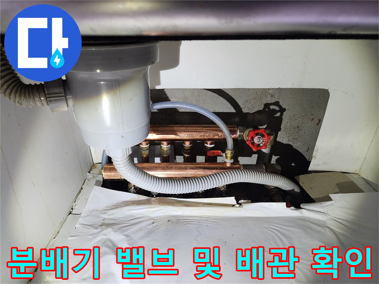 지하 창고 내 난방 분배기와 연결된 구리 배관의 근접 촬영 사진