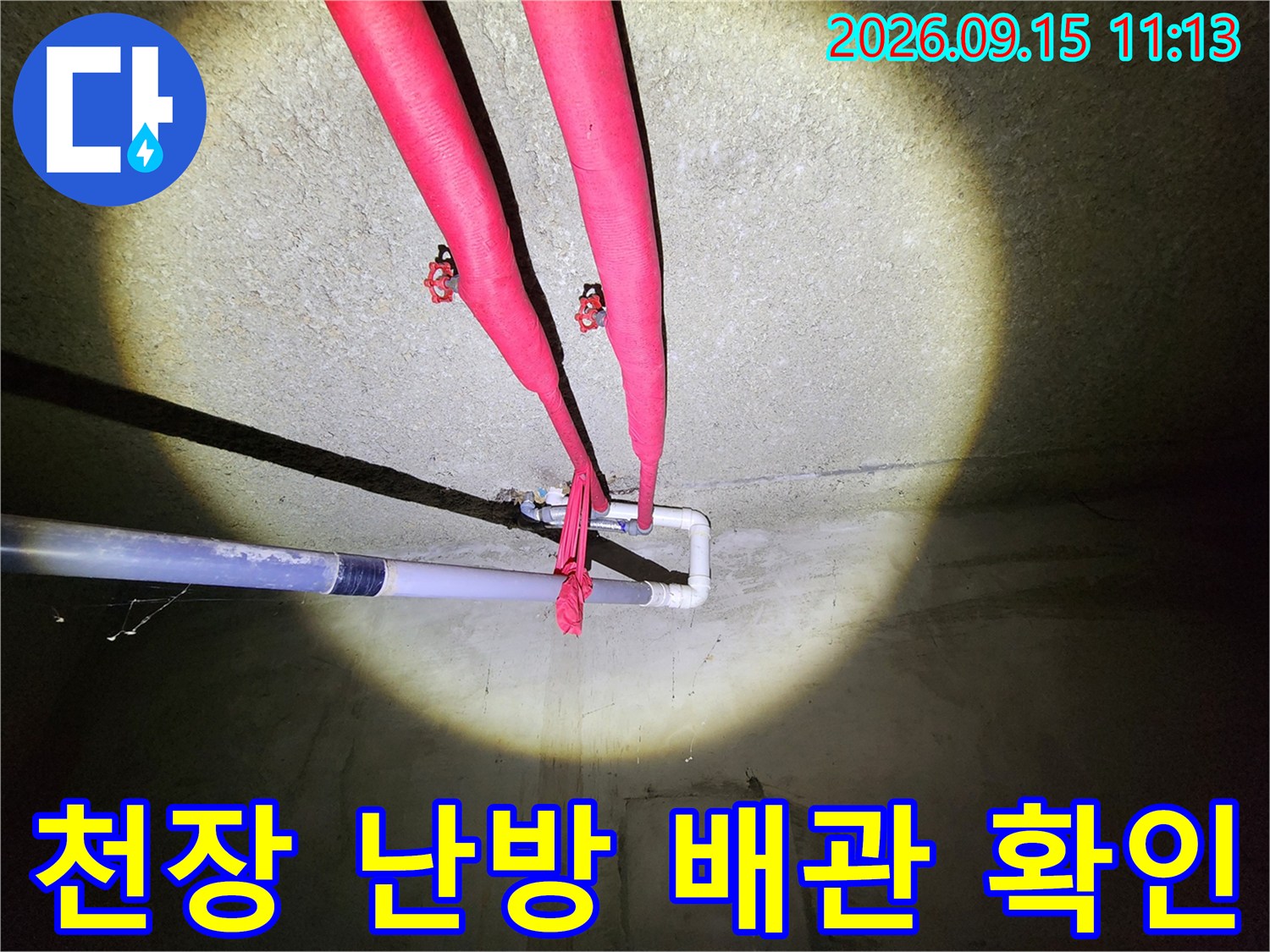 지하층 천장-붉은색 보온재가 씌워진 난방용 배관의 연결 부위 근접 촬영