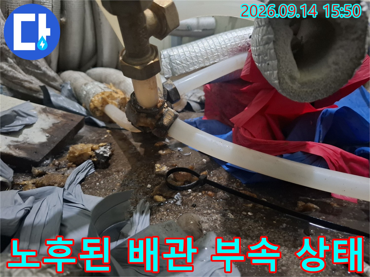 금속 밸브와 투명 호스 연결부의 노후된 상태를 근접 촬영하였습니다.