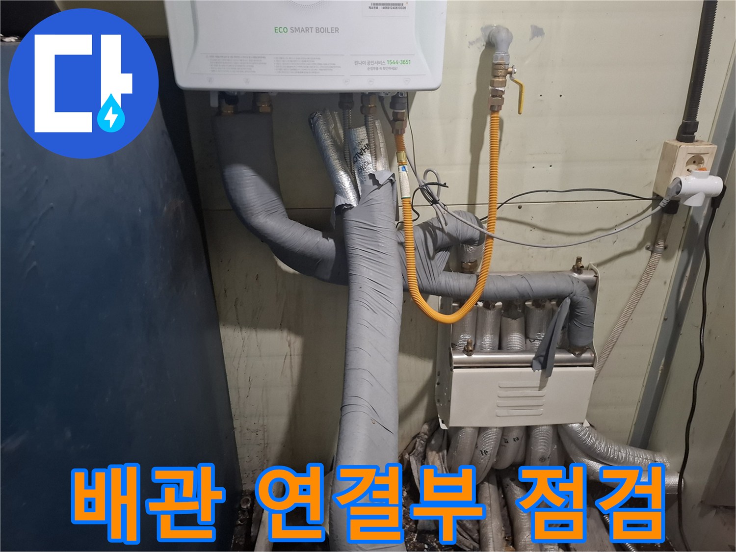 보일러 아래쪽의 노란색 호스와 회색 보온재 배관들의 모습