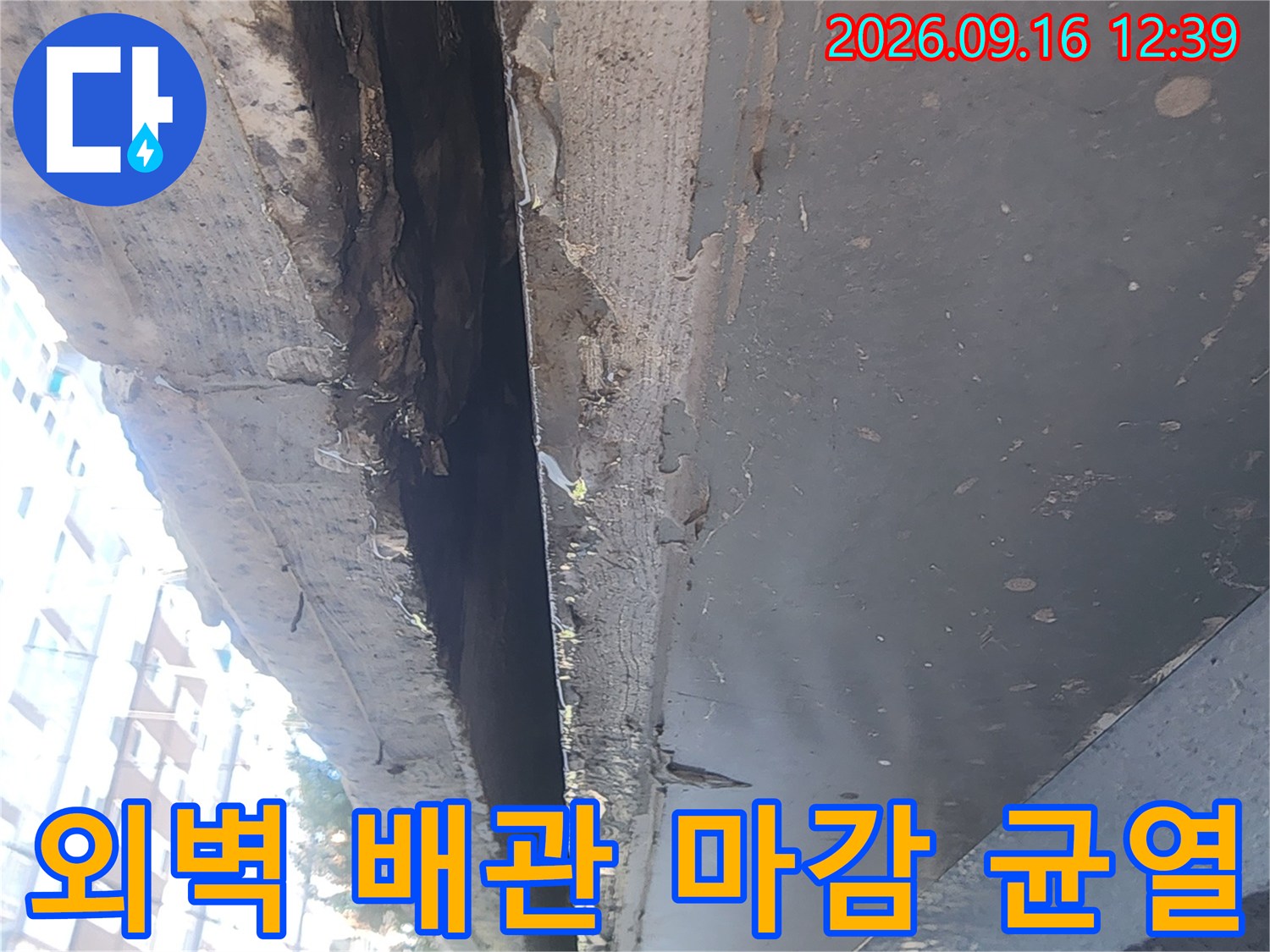 회색 마감재가 조각나서 떨어져 나간 배관 주변의 누수 의심 부위입니다.