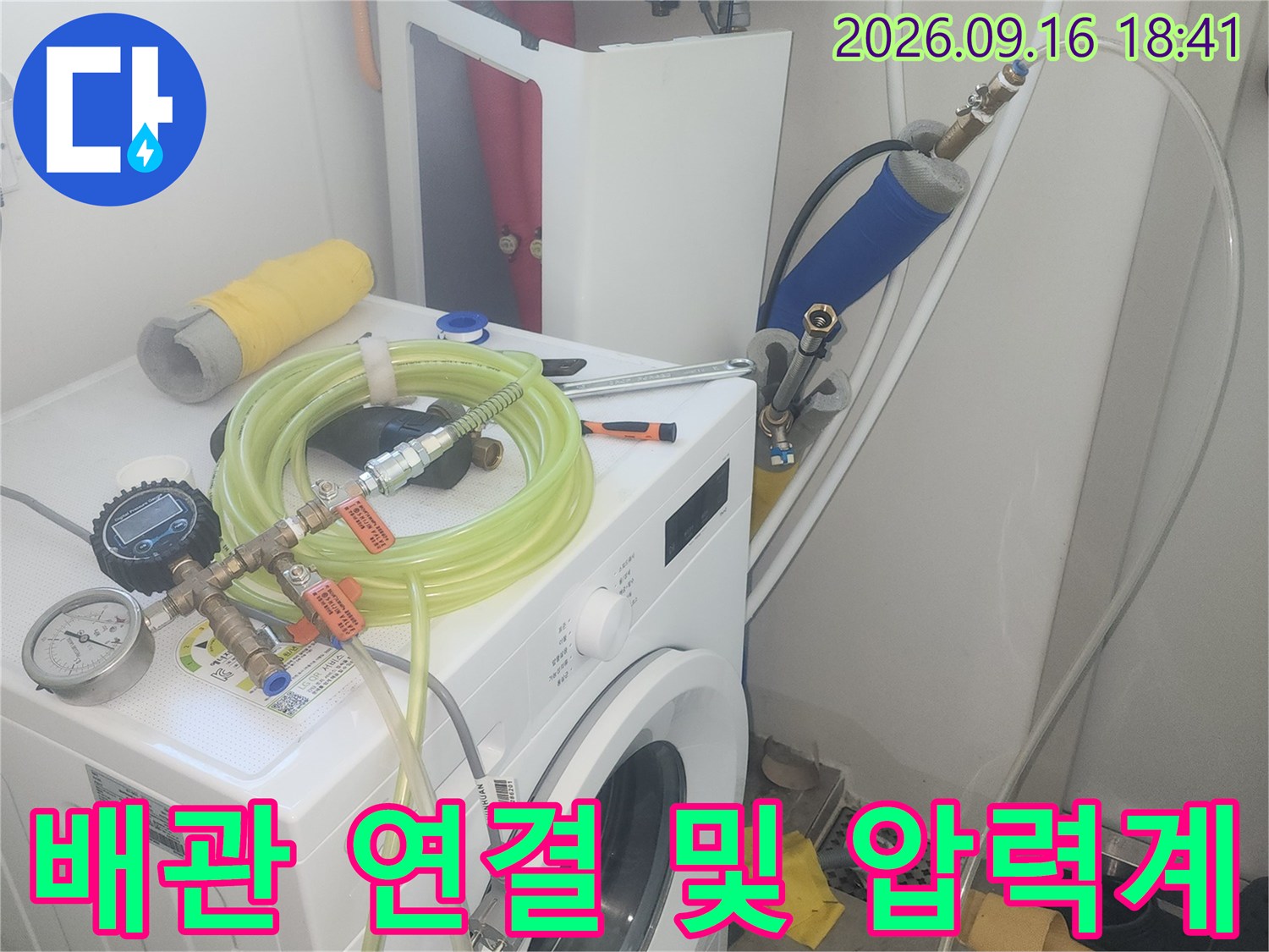 세탁실 수전에 설치된 압력계와 연결 호스의 점검 모습입니다.