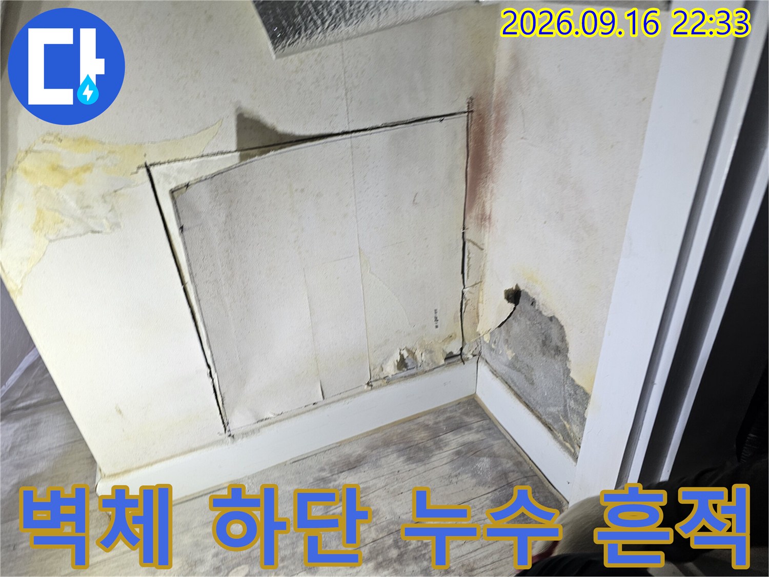 벽면 하단부의 물자국과 변색된 벽지 상태를 보여주는 사진