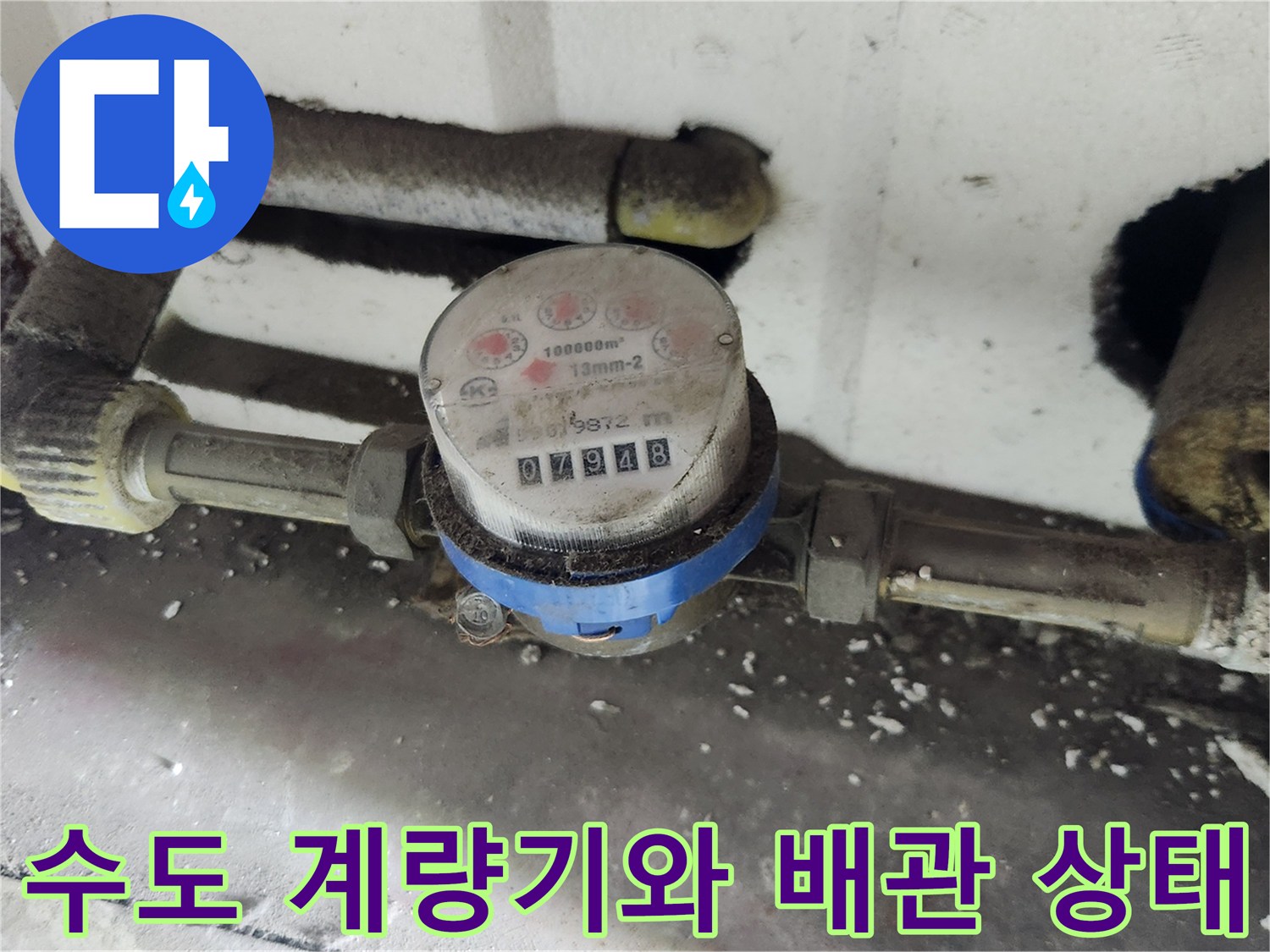 먼지가 쌓인 수도 계량기와 연결된 배관의 모습입니다.